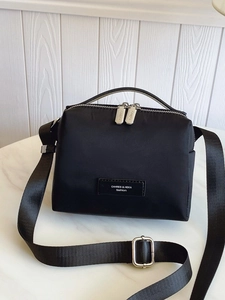 Sac bandoulière minimaliste en nylon noir avec zips argentés et bandoulière ajustable