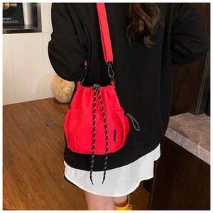Detailed view of red nylon drawstring bucket bag with mesh pockets and woven cord