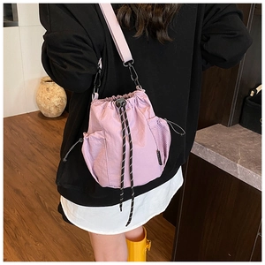 Detail view of light purple canvas drawstring bucket bag with adjustable shoulder strap