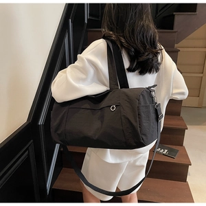 Detail of black nylon fitness bag with reinforced dual handles and adjustable shoulder strap