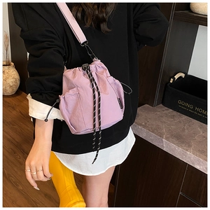 Detail view of a lavender drawstring bucket bag with functional mesh side pockets