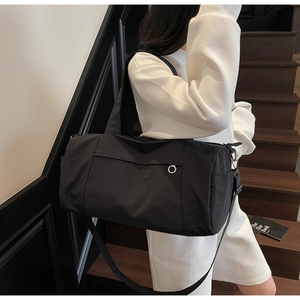 Black nylon travel bag on model showing large capacity and adjustable shoulder strap