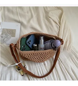 Macro shot showing internal compartments of the straw bag with phone and umbrella