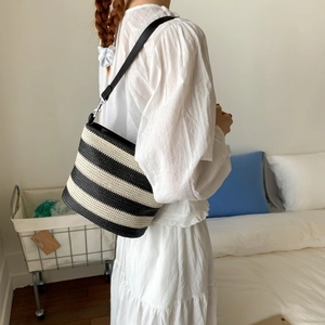 Detail shot of the black and white striped woven bucket bag with leather strap