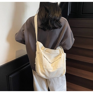 Detail view of large canvas crossbody bag showing spacious capacity and multi-pocket design