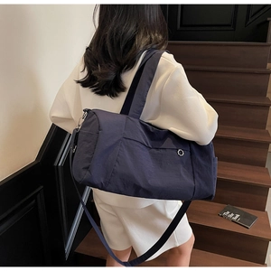 Navy blue travel bag with adjustable strap shown on stairs for gym and short trips