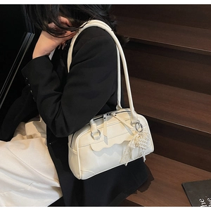 Detail of cream white pillow bag with wavy edges and elegant pearl lace charm pendant