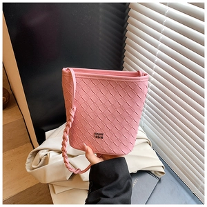 Detail of pink woven leather bucket bag with metallic logo and textured strap