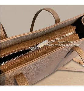 Detail of tan pebble leather tote bag showing high-quality silver zipper closure