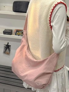 Pink crossbody dumpling bag with heart embroidery for women in a casual fashion style