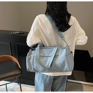 Detail of light blue waterproof travel bag showing adjustable strap and side pocket