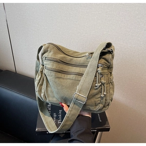 Detailed view of olive green canvas messenger bag with multi-pocket design and metal buckle