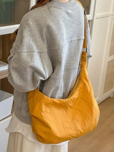 Minimalist yellow nylon crescent crossbody bag with adjustable wide strap on model