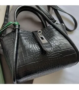 Detailed close-up of black crocodile pattern leather texture with silver metal clasp lock