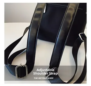 Detail view of adjustable wide shoulder straps with silver metal rings on a black backpack