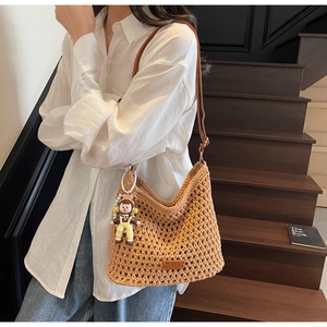 Brown crochet shoulder bag featuring a woven pattern and cute cartoon doll pendant