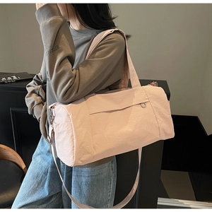 Action shot of a pink nylon gym bag with adjustable straps on a stylish model