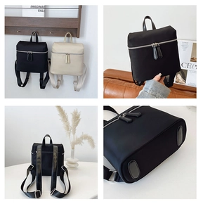 Detail view of black and beige backpacks showing silver zippers and nylon texture