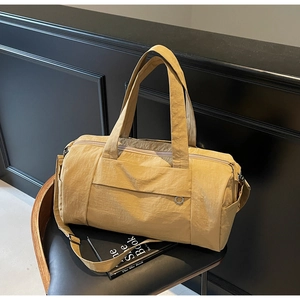 Detailed shot of mustard yellow gym bag on black leather chair with nylon texture