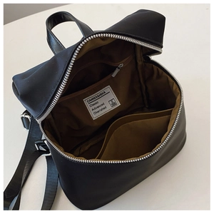 Internal view showing organized pockets and brown fabric lining of the black backpack