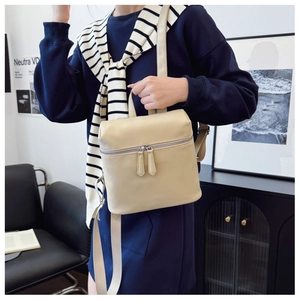 Detail of minimalist beige faux leather backpack with smooth zippers and adjustable straps
