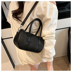 Detail of black cylindrical crossbody bag with wavy texture and silver metal hardware