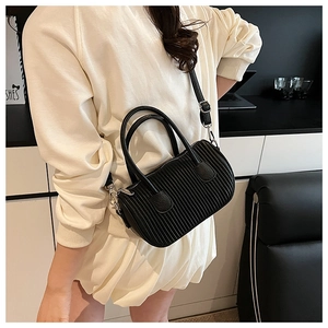 Detail of black pleated Boston bag showing soft texture and adjustable shoulder strap