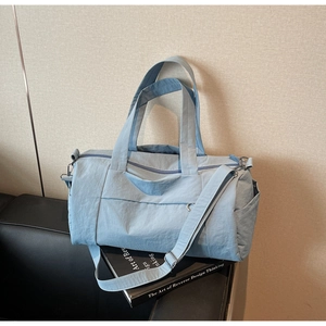 Detail of light blue yoga gym bag featuring adjustable shoulder straps and nylon texture