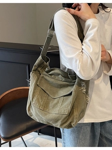 Olive green canvas crossbody bag with frayed edges and adjustable wide strap