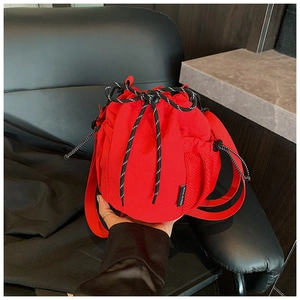 Detail of red nylon bucket bag featuring striped drawstring and mesh side pocket