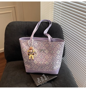 Close-up of lavender floral jacquard tote with silver bow and pearl doll pendant