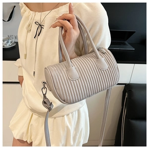 Detail of light grey pleated boston bag with lychee texture and dual handles