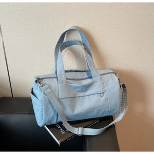 Detailed side view of light blue travel bag showing fabric texture and adjustable strap
