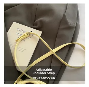Detail view of adjustable leather shoulder strap with metal buckle for bucket bag
