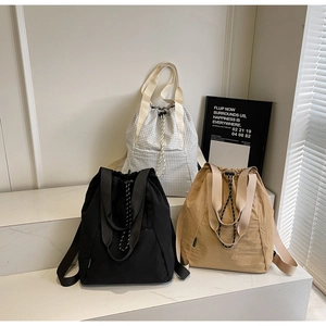 Minimalist drawstring tote bags in black, khaki, and plaid pattern with wide straps