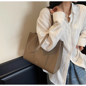 Close-up of a large coffee-colored lychee leather tote bag for professional office style