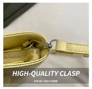 Detail of yellow leather handbag showing silver metal hooks and high-quality stitching