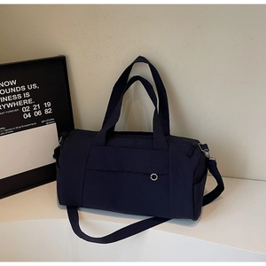 Close-up of a navy blue waterproof nylon travel bag with handles and adjustable strap