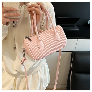 Detailed macro of pink ruched cylinder bag showing vertical pleated faux leather texture
