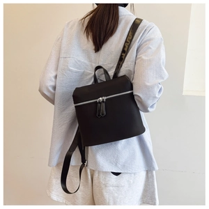 Black lightweight nylon backpack for women shown from the back view on a model
