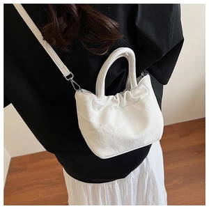 Detailed back view of a white ruched bucket bag with handle and silver metal hooks