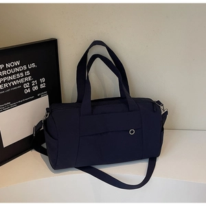 Macro shot of dark blue canvas travel bag with wide handles on a geometric white stand