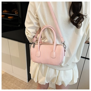 Detail view of pink pleated leather cylinder bag with silver hardware and shoulder strap