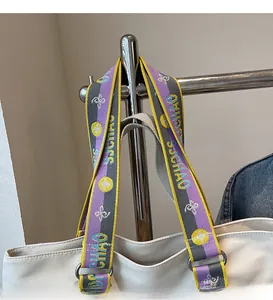 Detail of wide woven shoulder strap with colorful stripes and metallic rings on canvas tote