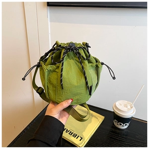 Close-up of green drawstring bucket bag showing nylon texture and mesh side pocket