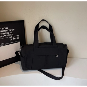 Detail showing high-quality black nylon travel bag with reinforced handles and silver metal eyelet