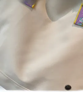 Detailed close-up of high-quality canvas fabric texture and purple embroidered trim