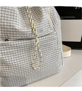 Detailed close-up of the black and white checkered fabric and woven drawstring cord