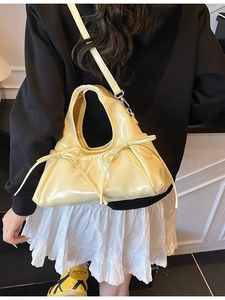 Fashionable light yellow glossy handbag with bow details and detachable shoulder strap