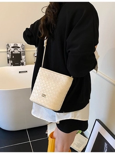 Chic cream woven bucket bag with sleek strap and premium minimalist texture design